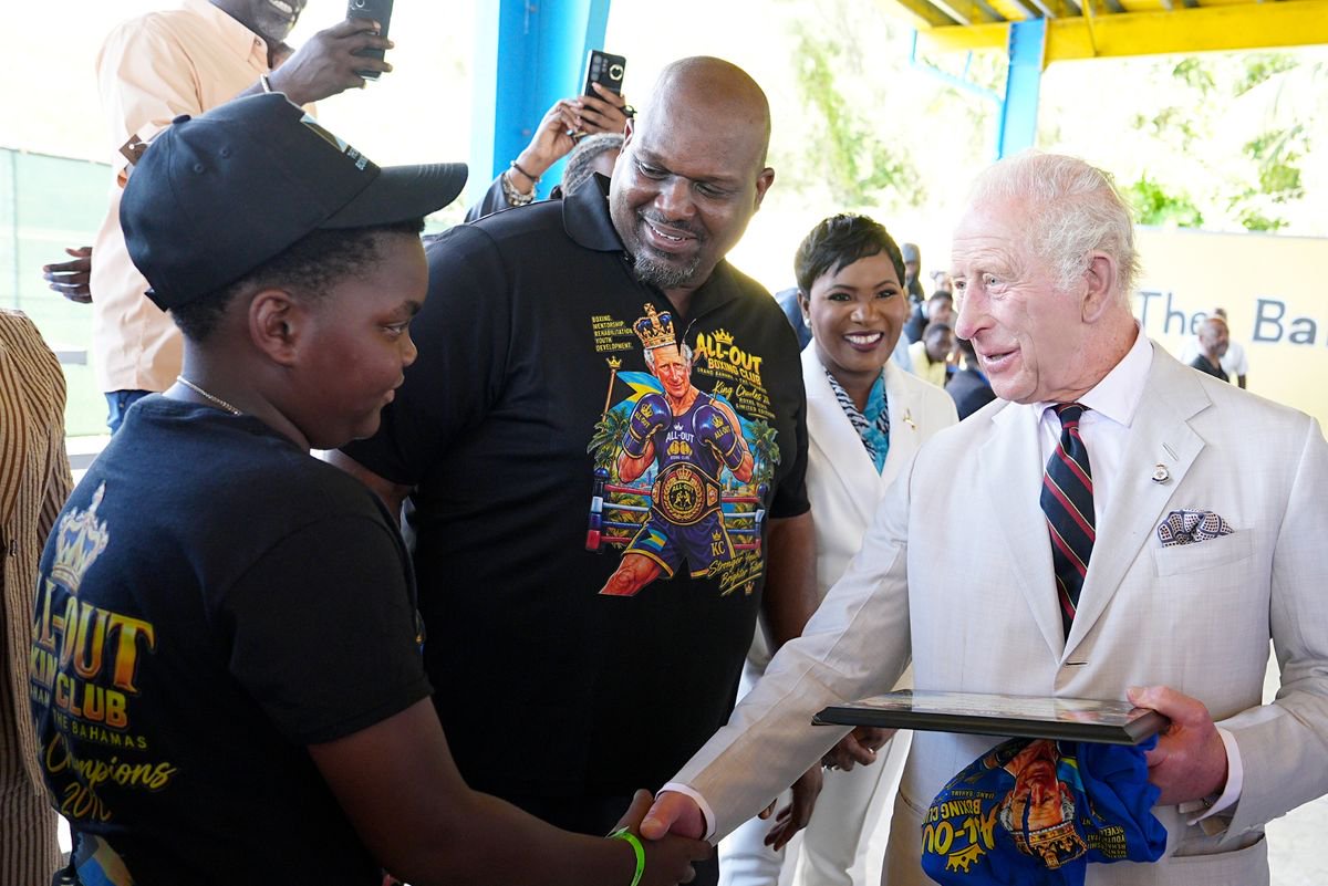 King Charles III is presented with a t-shirt - featuring an illustration depicting him as a boxer