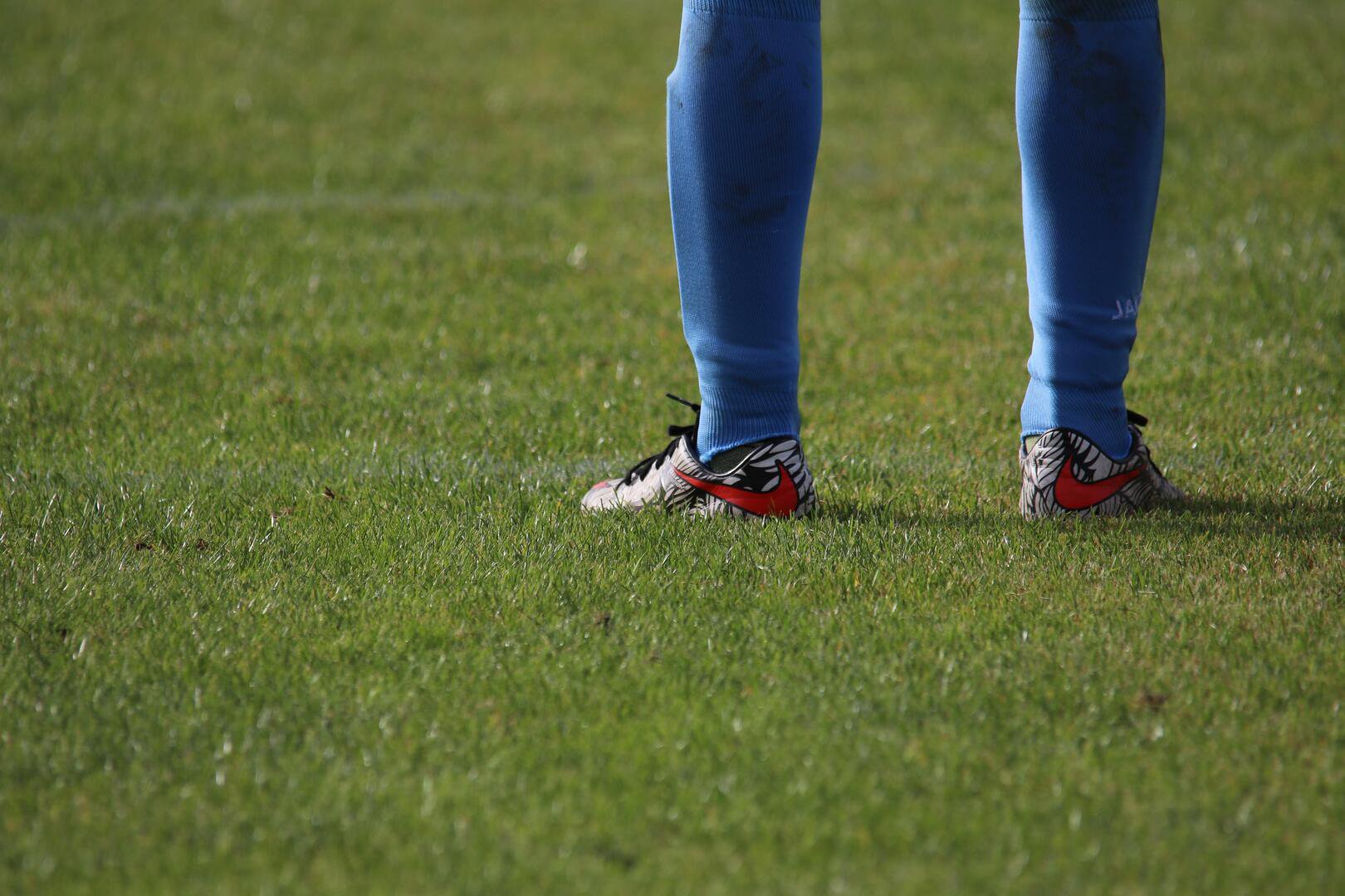 Nahaufnahme Fußballschuhe und blaue Stutzen