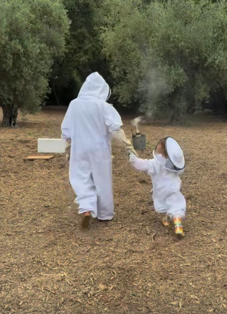 Meghan Markle and Lilibet wearing beekeeping suits.