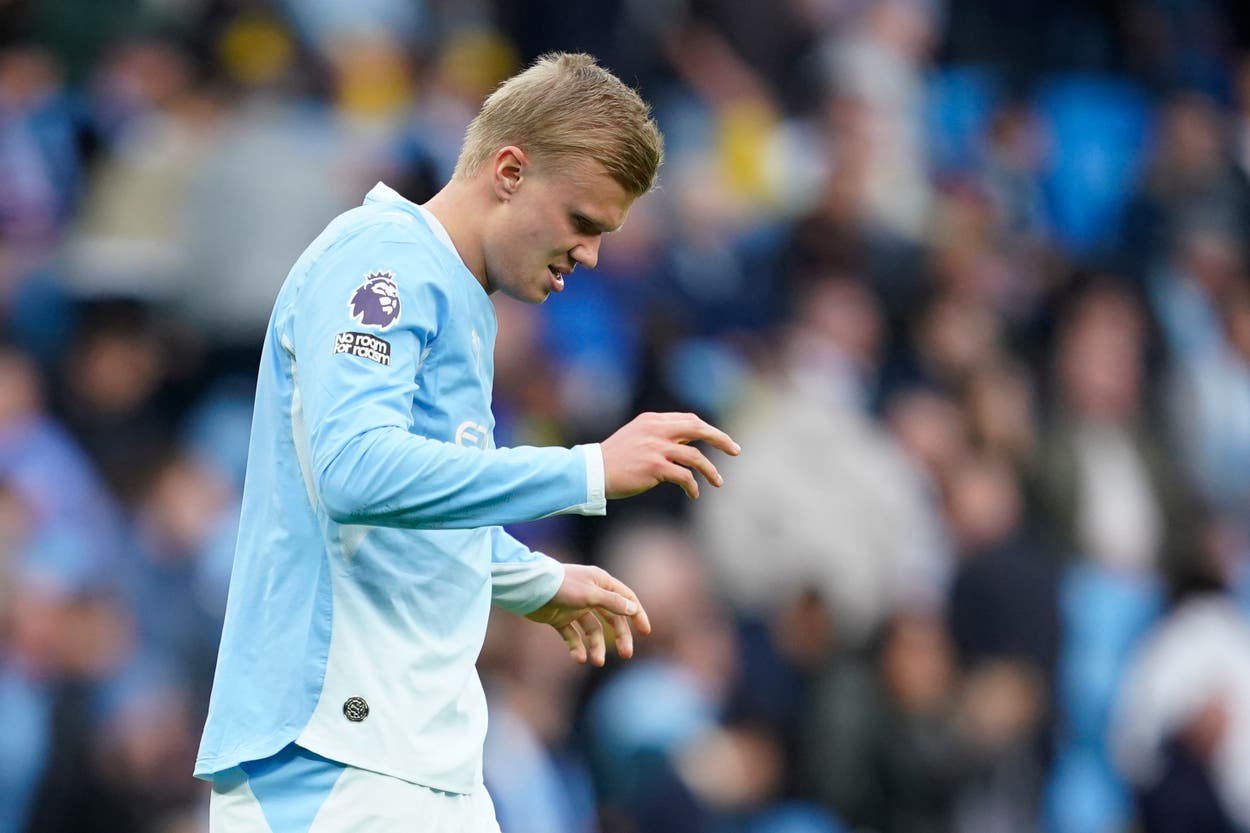 Manchester City's Erling Haaland grimaces on the pitch as he hobbles down the tunnel