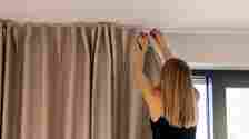 Woman Hanging up curtains