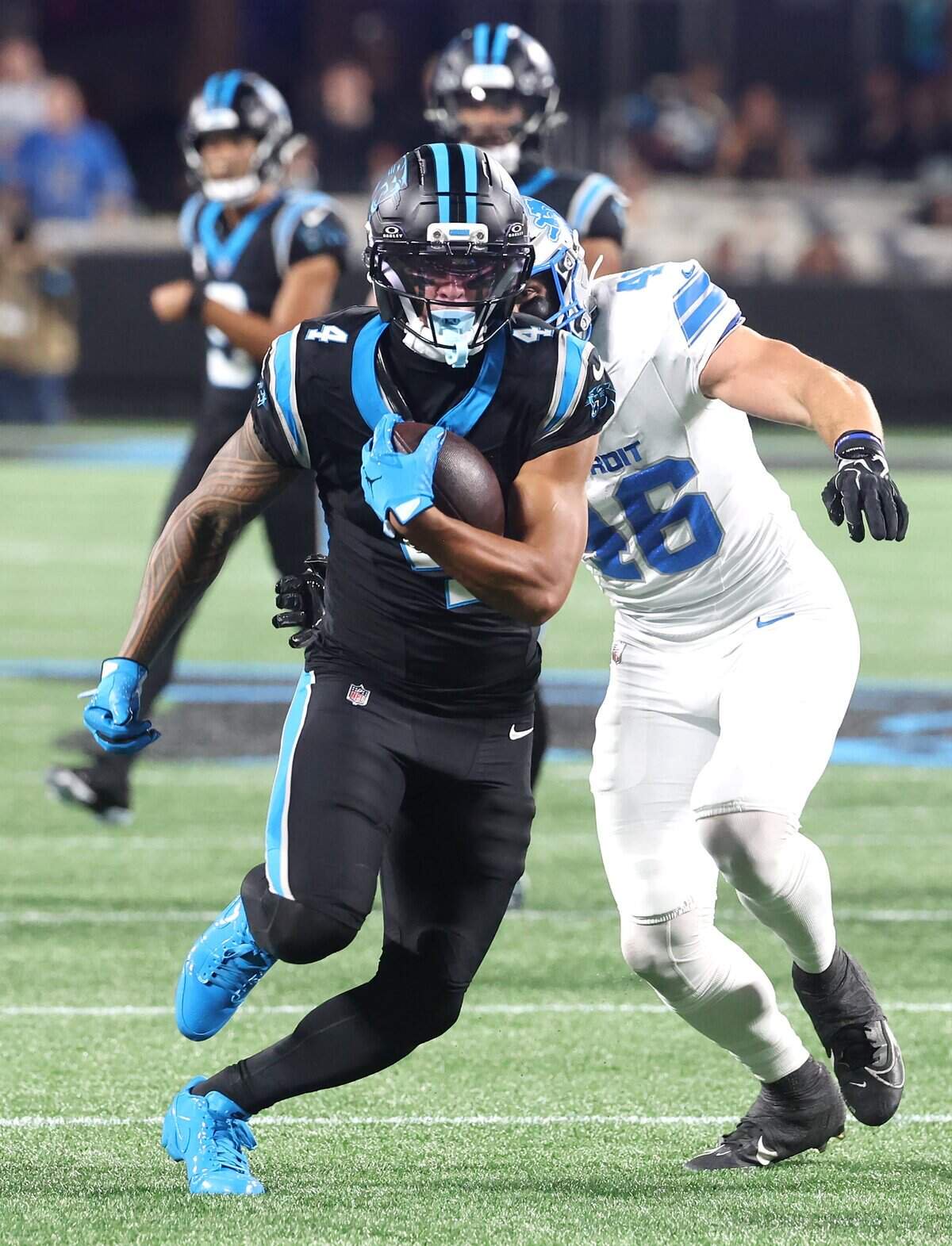 Carolina Panthers wide receiver Tetairoa McMillan, left, breaks free of Detroit Lions linebacker Jack Campbell, right, following a pass reception at Bank of America Stadium on Sunday, October 4, 2026. The Panthers defeated the Lions 32-26.
