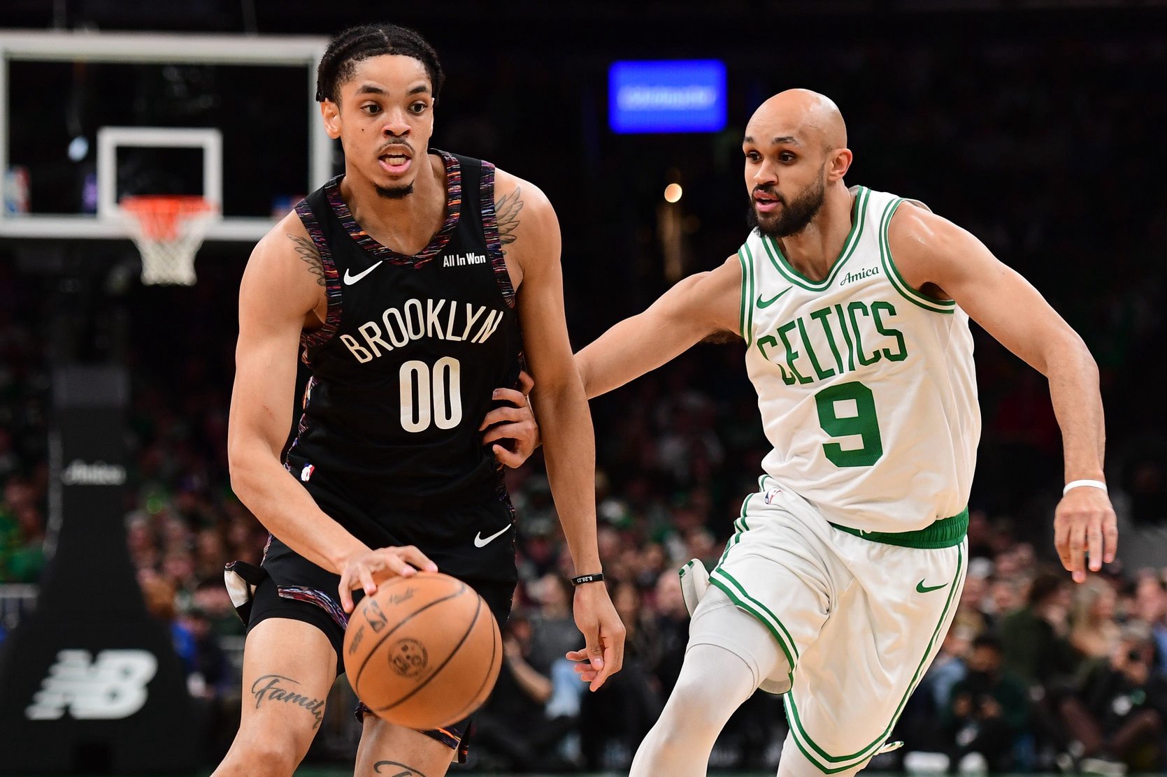 Feb 27, 2026; Boston, Massachusetts, USA; Brooklyn Nets forward Josh Minot (00) controls the ball while Boston Celtics guard Derrick White (9) defends during the first half at TD Garden. Mandatory Credit: Bob DeChiara-Imagn Images