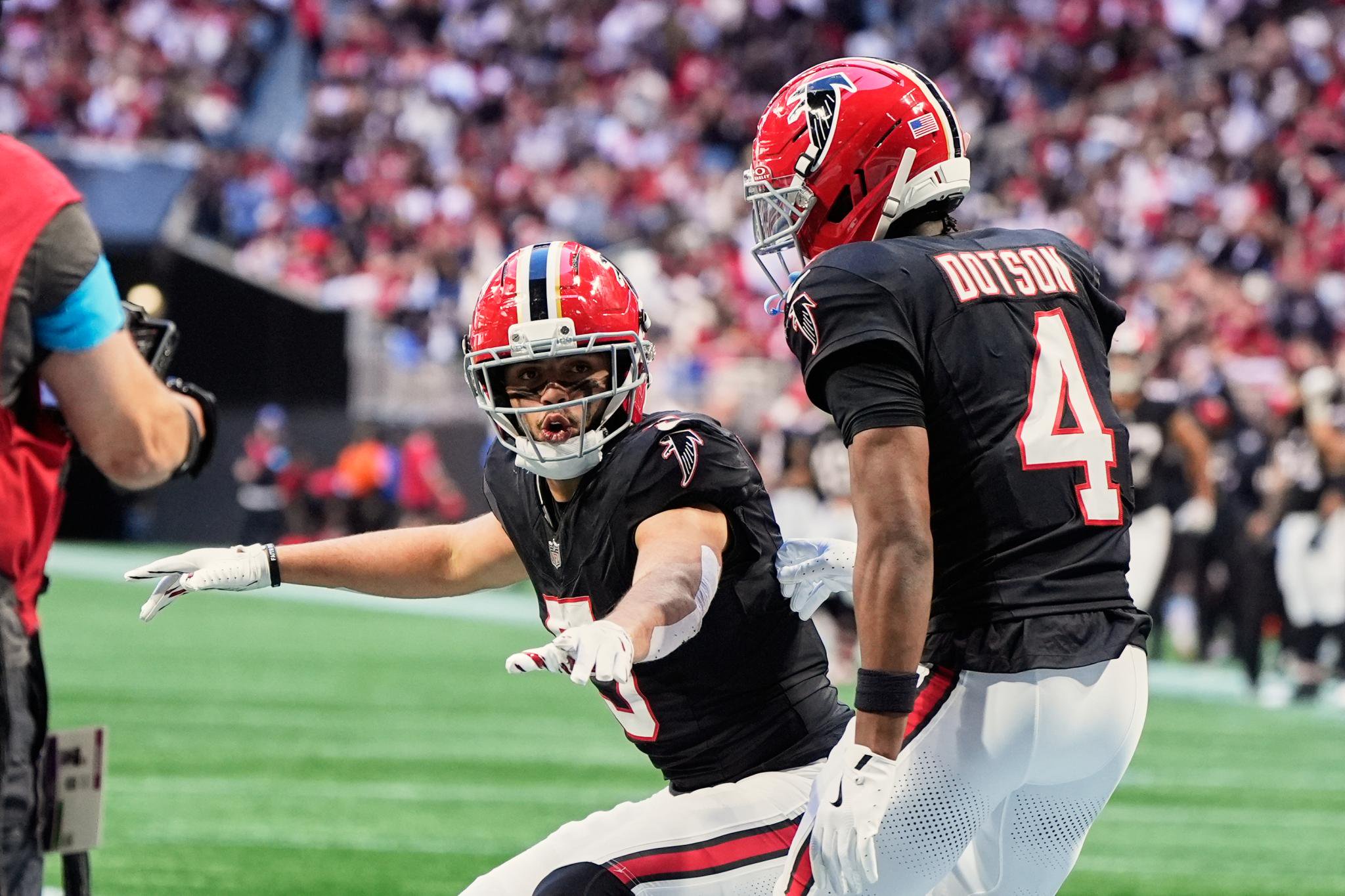 Atlanta Falcons football players Drake London and Jahan Dotson on the field during a game.
