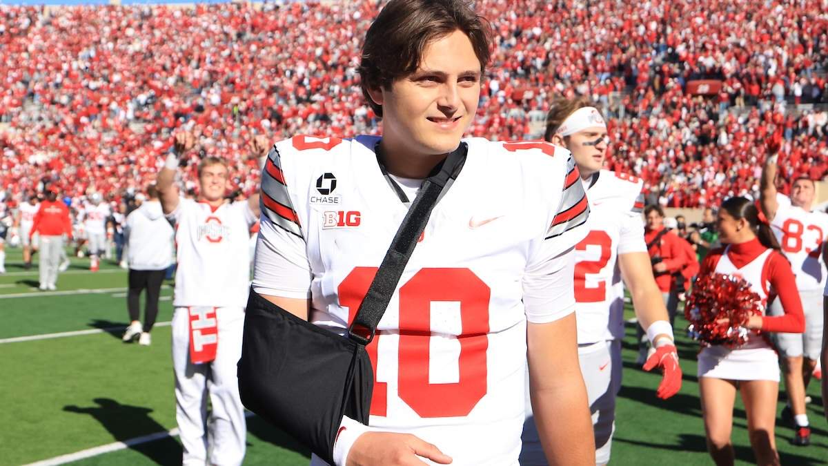 Julian Sayin #10 of the Ohio State Buckeyes walks off the field with his arm in a sling