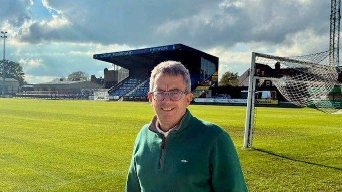 A smiling Stafford Rangers chief executive Dave Smith poses behind the goal at the non-league club's 3,130-capacity Marston Road ground