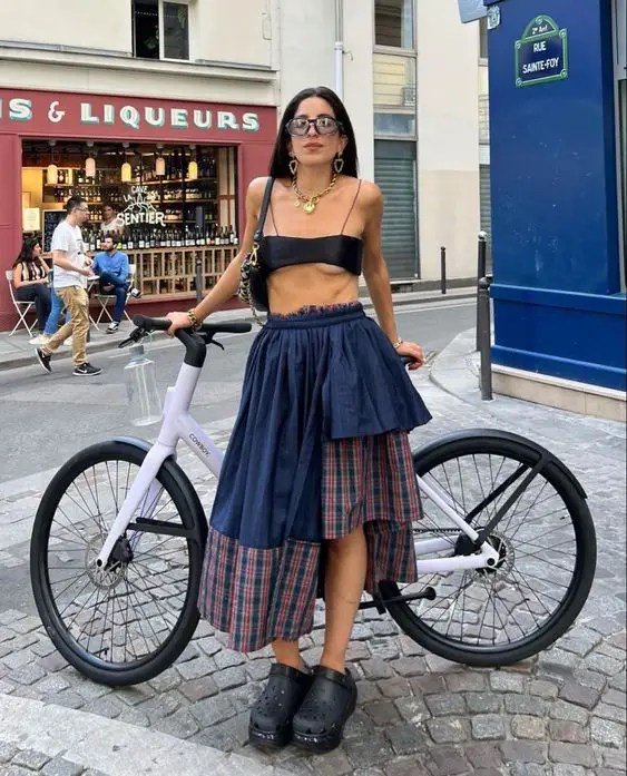 a lady leaning on a bicycle while wearing wedge croc heels