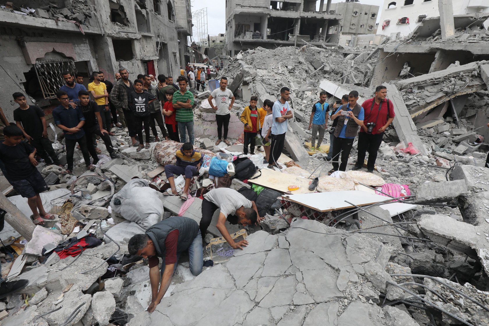 Palestinians search for bodies and survivors in the rubble of a destroyed house following an Israeli air strike