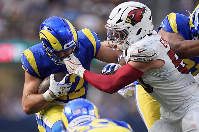 Los Angeles Rams wide receiver Puka Nacua, left, has his face mask grabbed by Arizona Cardinals linebacker Jack Gibbens during the second half of an NFL football game in Inglewood, Calif., Sunday, Oct. 18, 2026. (AP Photo/Gregory Bull)
