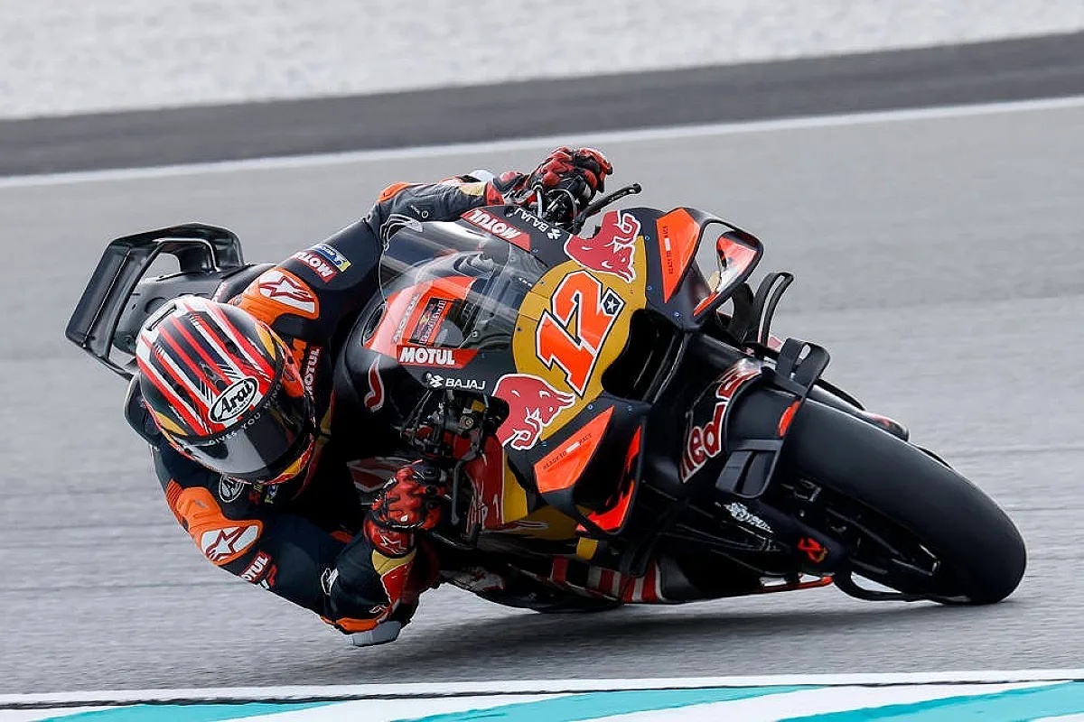 Rider in black and orange leathers leaning through a corner on a Red Bull KTM MotoGP bike, number 12, at Sepang