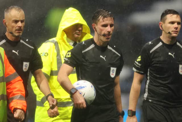 Referee Elliot Bell (Ctr) leads his officials off the pitch at the final whistle.