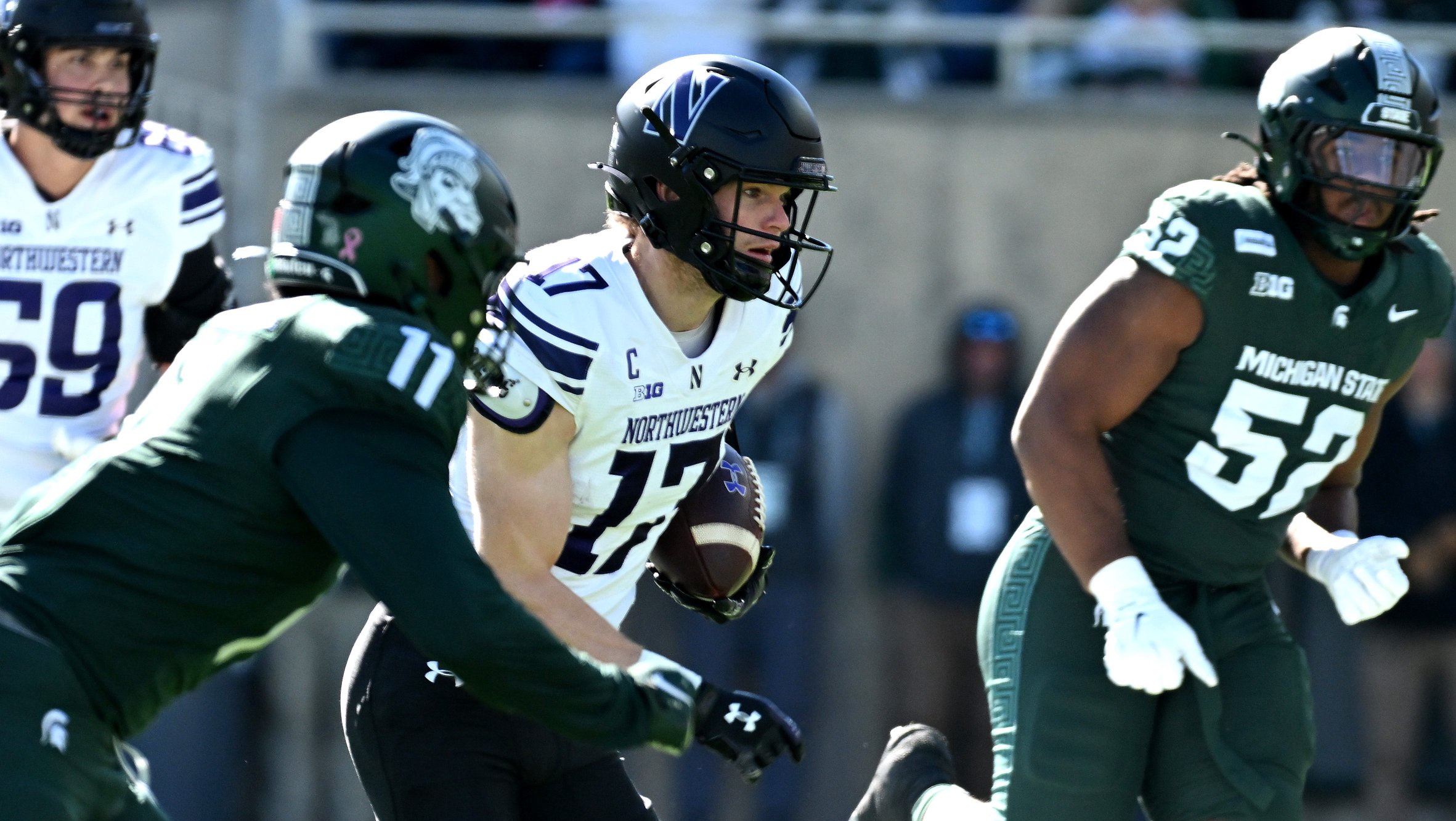 Oct 17, 2026; East Lansing, Michigan, USA;  Northwestern Wildcats wide receiver Griffin Wilde (17) runs through Michigan State Spartans defenders for a first down during the second quarter at Spartan Stadium.  Mandatory Credit: Dale Young-Imagn Images