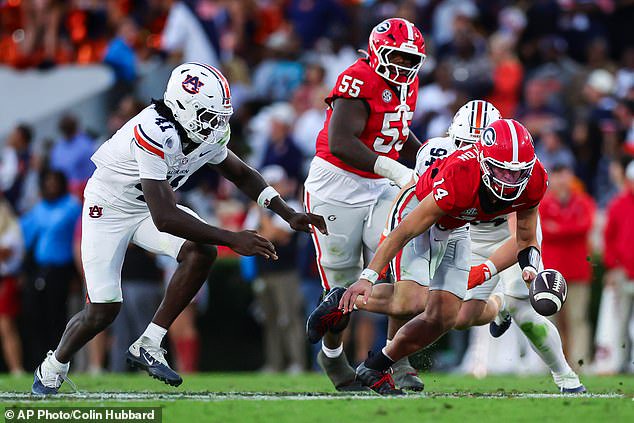 Georgia quarterback Gunner Stockton, right, fumbles against Auburn on Saturday in Athens