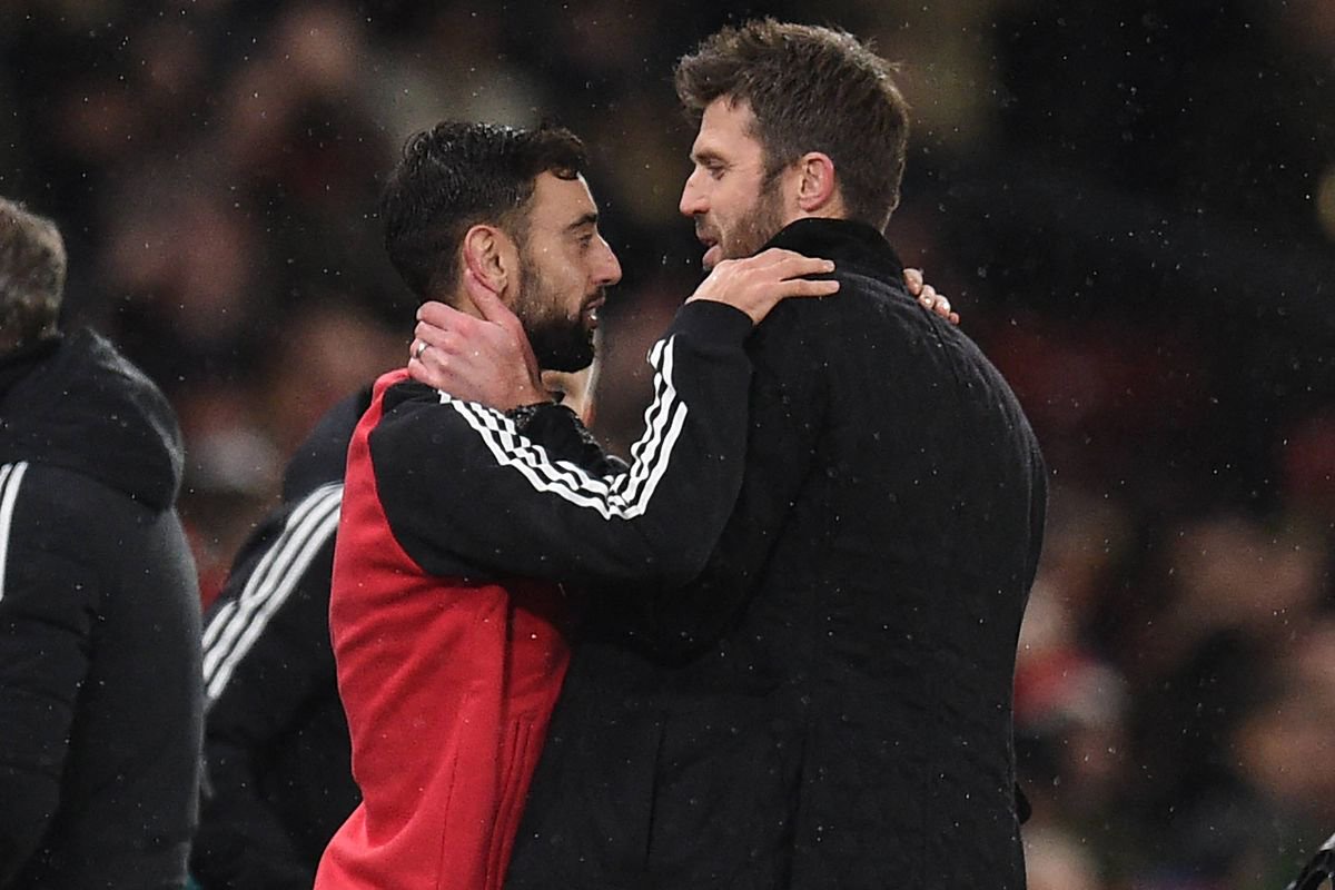Manchester United's manager Michael Carrick (R) speaks with Manchester United's Portuguese midfielder Bruno Fernandes (L)