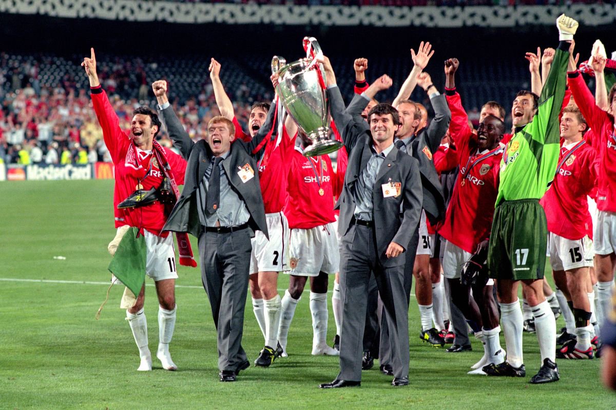 Paul Scholes and Roy Keane, hold aloft the trophy.