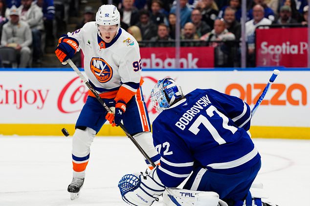 Toronto Maple Leafs goaltender Sergei Bobrovsky (72) makes a save as New York Islanders' Simon Holmstrom (92) looks for the rebound during the first period of an NHL hockey game in Toronto, Saturday, Oct. 17, 2026. (Frank Gunn/The Canadian Press via AP)
