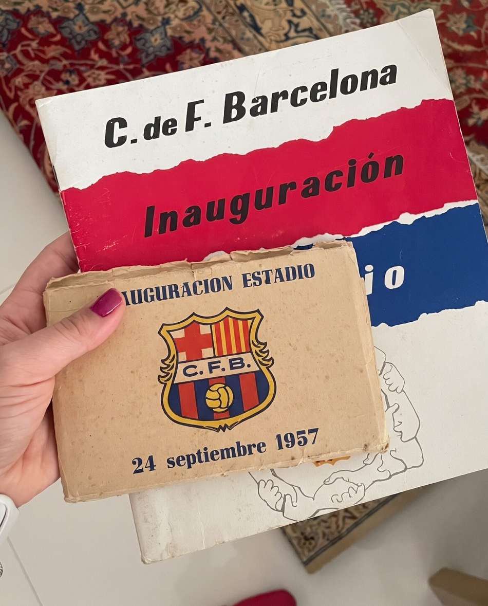 Mão segurando cartão com o escudo do FC Barcelona e texto de inauguração do Camp Nou, 24 septiembre 1957.