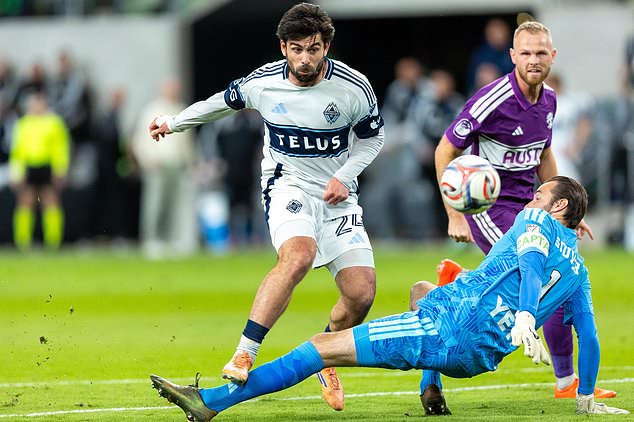 Austin FC goalkeeper Brad Stuver (1) makes a stop against Vancouver Whitecaps forward Brian White (24) with Austin FC defender Mikkel Desler (3) watching during the second half of an MLS soccer match in Austin, Texas, Saturday, Oct. 17, 2026. (AP Photo/Stephen Spillman)