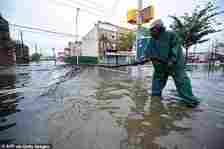 New York City is one of the top metropolises at risk of sewage flooding because the pipes, built in the mid-1850s, weren't made to withstand rainfall exceeding 1.75 inches per hour. Pictured: Man tries to unblock sewage grate after Hurricane Irene hit Coney Island in 2011