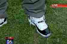 Close-up of a person's feet wearing classic sneakers on grass, focus on shoe design
