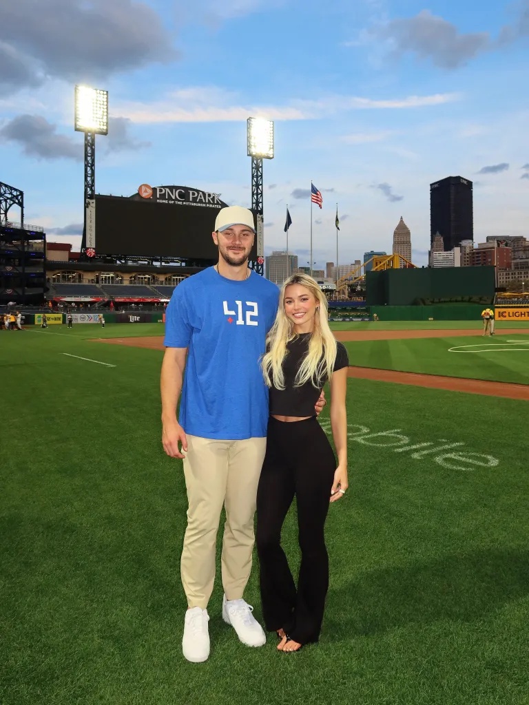 A man and woman standing on a baseball field at PNC Park, home of the Pittsburgh Pirates.