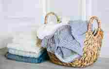 Laundry basket with clothes and pile of laundry