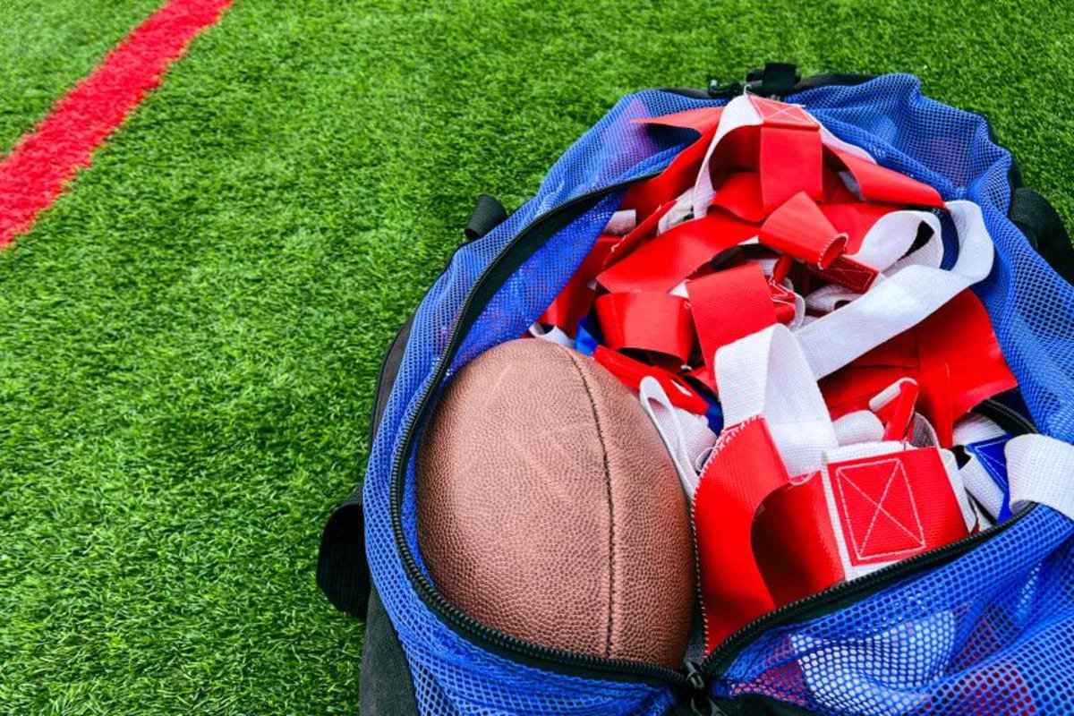 High school flag football equipment on green turf.