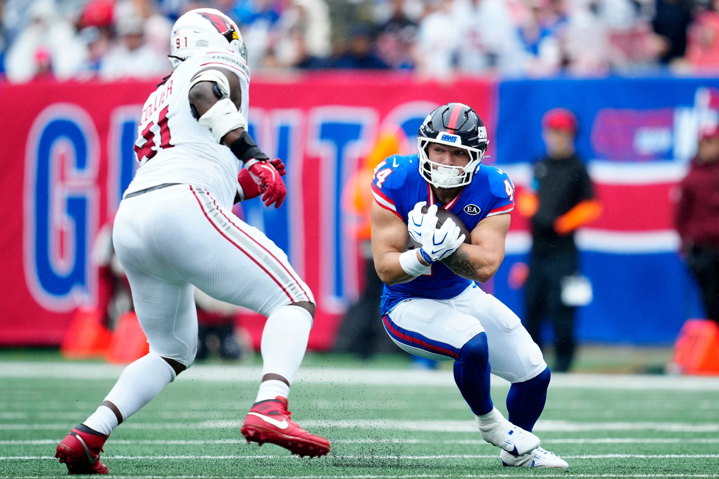 New York Giants running back Cam Skattebo (44) runs with the ball as Arizona Cardinals defensive end L.J. Collier (91) approaches,  Sunday, October 4, 2026, in East Rutherford.