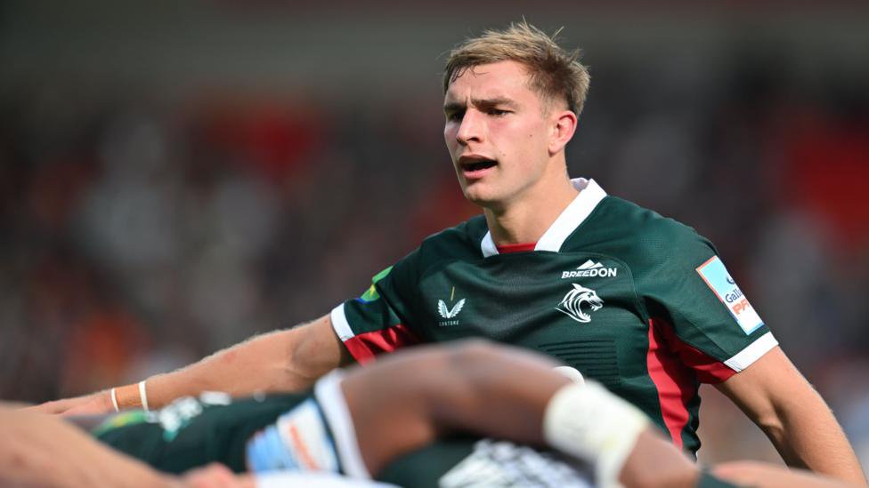 Jack van Poortvliet orchestrating his scrum who are seen just below him in soft focus, all wearing green Leicester tops