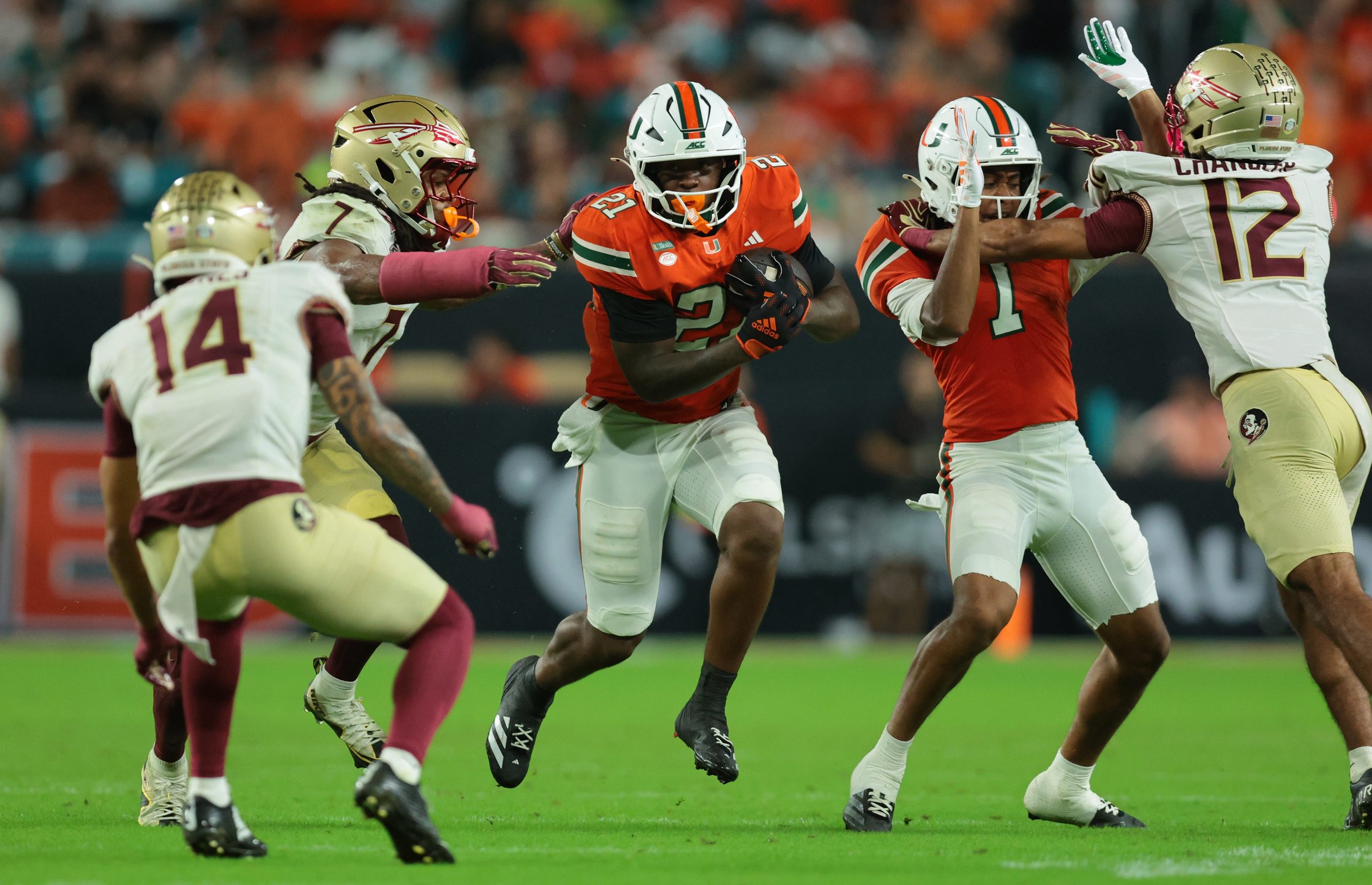 Miami running back Javian Mallory (21) carries the ball as Florida State defensive back Ashlynd Barker (7) tries to make a tackle during the third quarter at Hard Rock Stadium. 