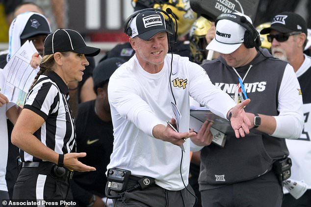 Central Florida head coach Scott Frost, center, argues with an official on the sideline during the first half of an NCAA college football game against BYU, Saturday, Oct. 24, 2026, in Orlando, Fla. (AP Photo/Phelan M. Ebenhack)