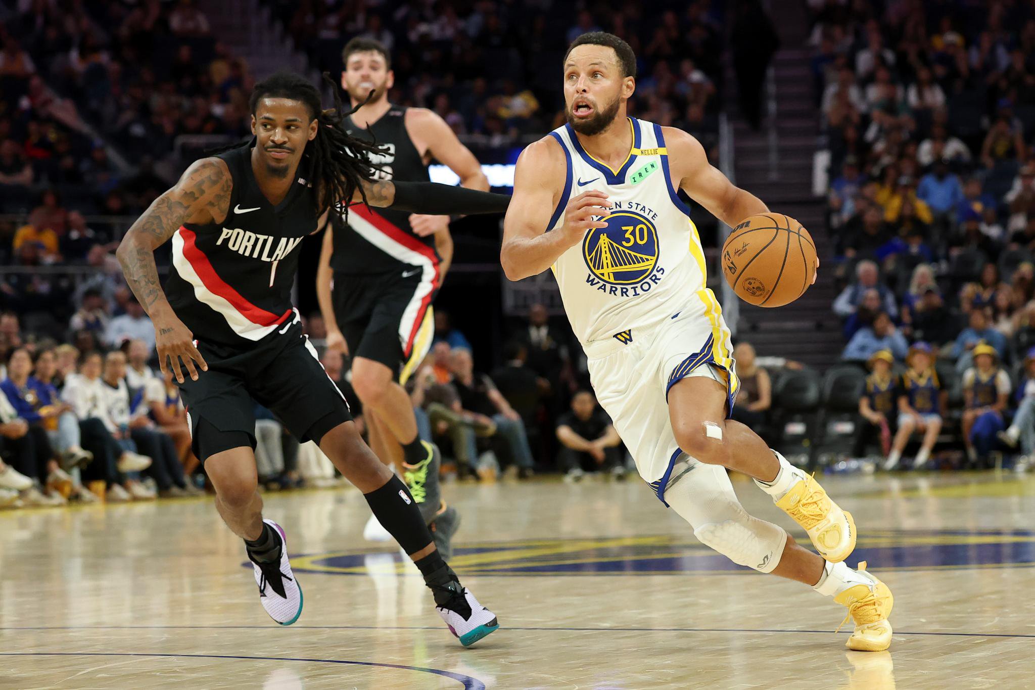 Golden State Warriors' Stephen Curry (30) dribbles past Portland Trail Blazers' Ja Morant (1) during a preseason NBA basketball game.