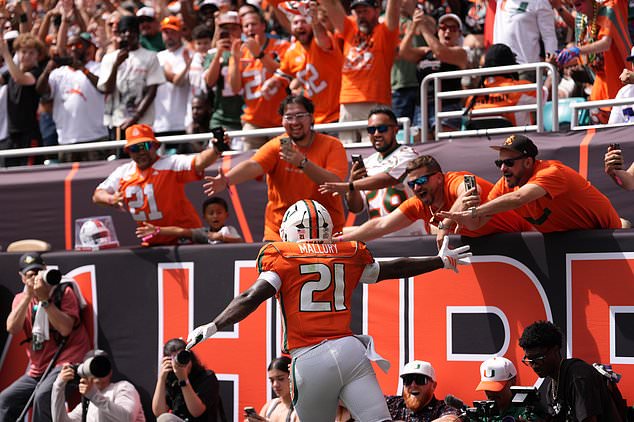 Miami running back Javian Mallory (21) celebrates with fans after scoring a touchdown during the first half of an NCAA college football game against Pittsburgh, Saturday, Oct. 24, 2026, in Miami Gardens, Fla. (AP Photo/Rebecca Blackwell)
