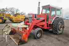 A 1971 IH 1466 tractor with loader and claw grip attachment.