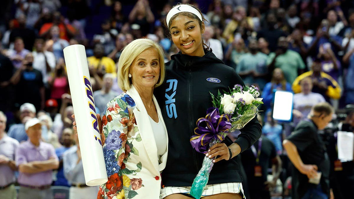 Kim Mulkey and Angel Reese pose together before a preseason game.