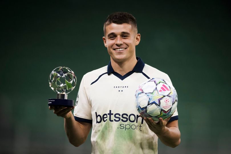 Nicolo Tresoldi of Club Brugge KV celebrates his hat-trick while holding the 'Player of the Match' award and the match ball at the end of the UEFA Champions League 2026/27 league phase football match between FC Internazionale and Club Brugge