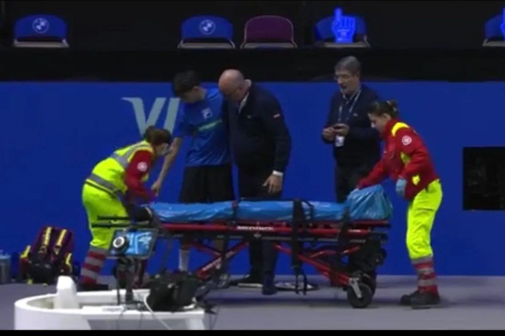 An image collage containing 1 images, Image 1 shows Medical staff prepare a stretcher for a ball boy on a tennis court, with officials assisting