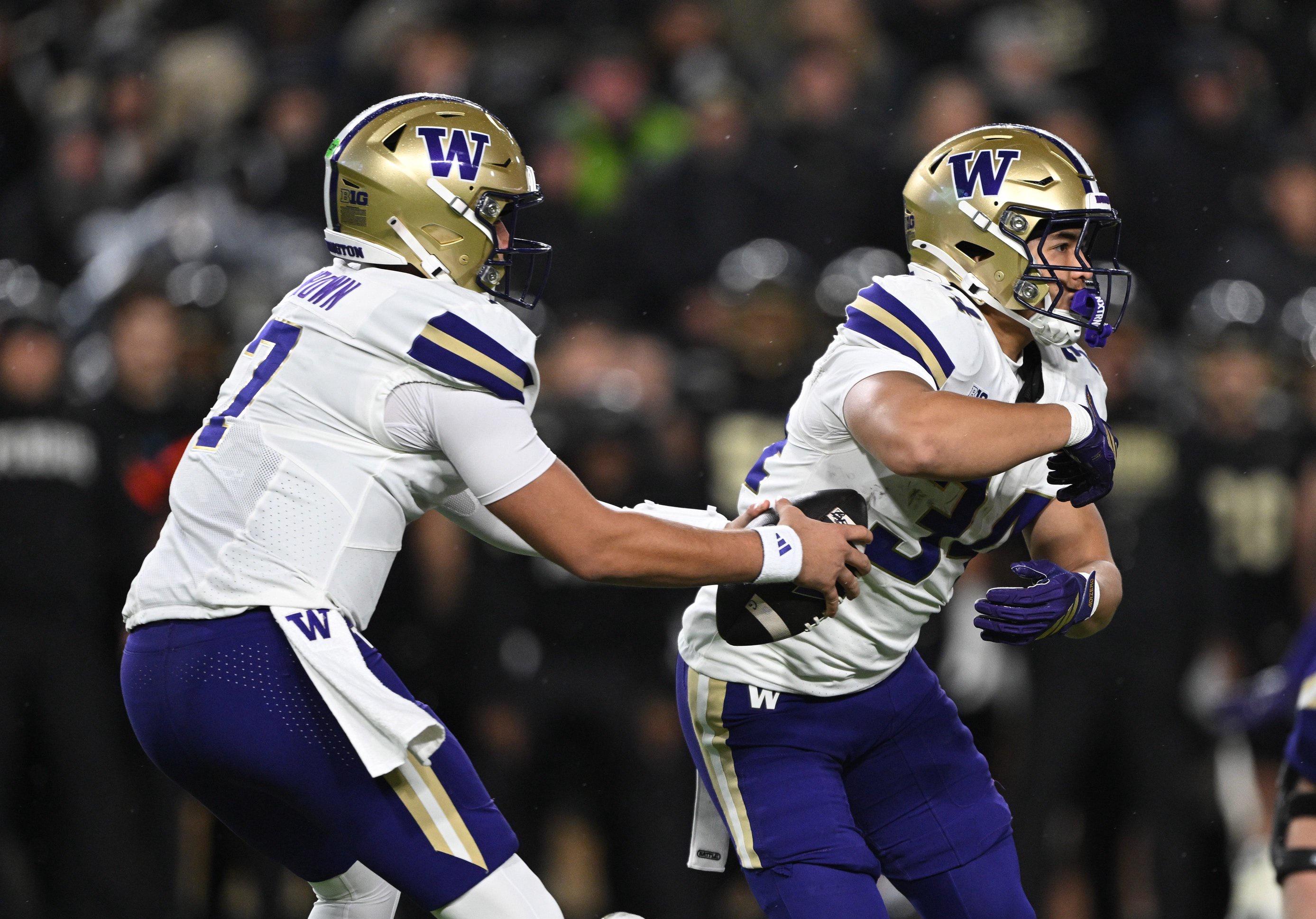 Oct 16, 2026; West Lafayette, Indiana, USA;  Washington Huskies quarterback Elijah Brown (7) fakes a handoff to Washington Huskies running back Brian Bonner (34) during the first quarter abasing the Purdue Boilermakers at Ross-Ade Stadium.  Mandatory Credit: Marc Lebryk-Imagn Images