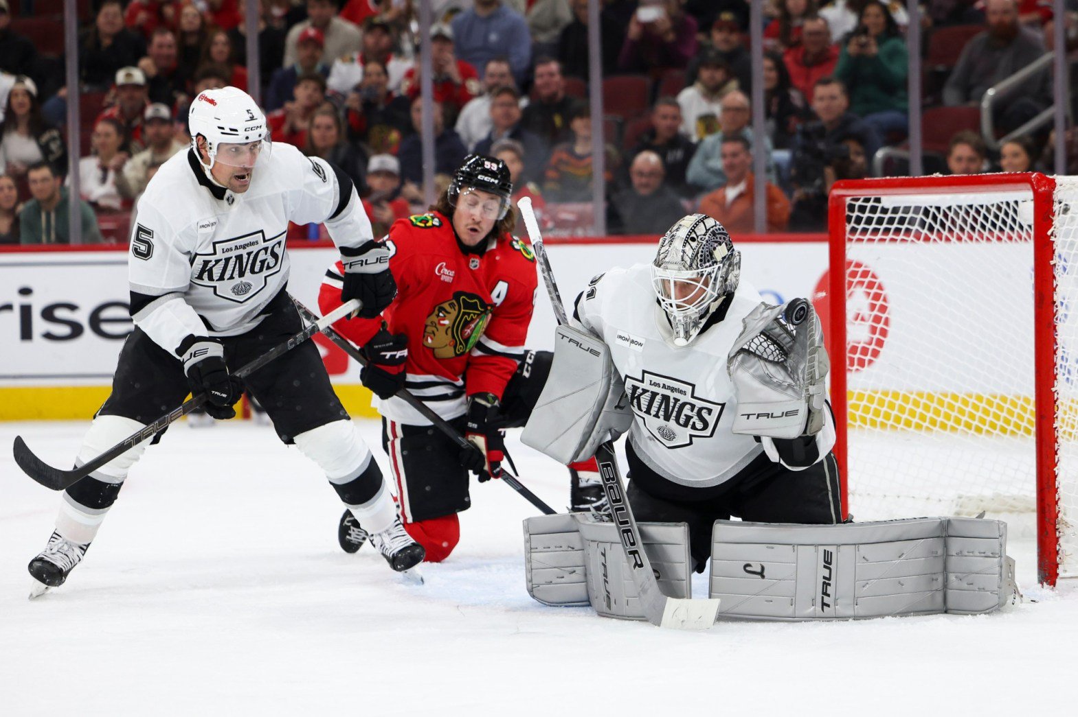 Kings goaltender Anton Forsberg, right, makes a save as defenseman Cody Ceci (5) and Chicago Blackhawks left wing Tyler Bertuzzi, center, watch during the second period on Tuesday night in Chicago. The Kings lost, 2-1. (AP Photo/Jessie Alcheh)
