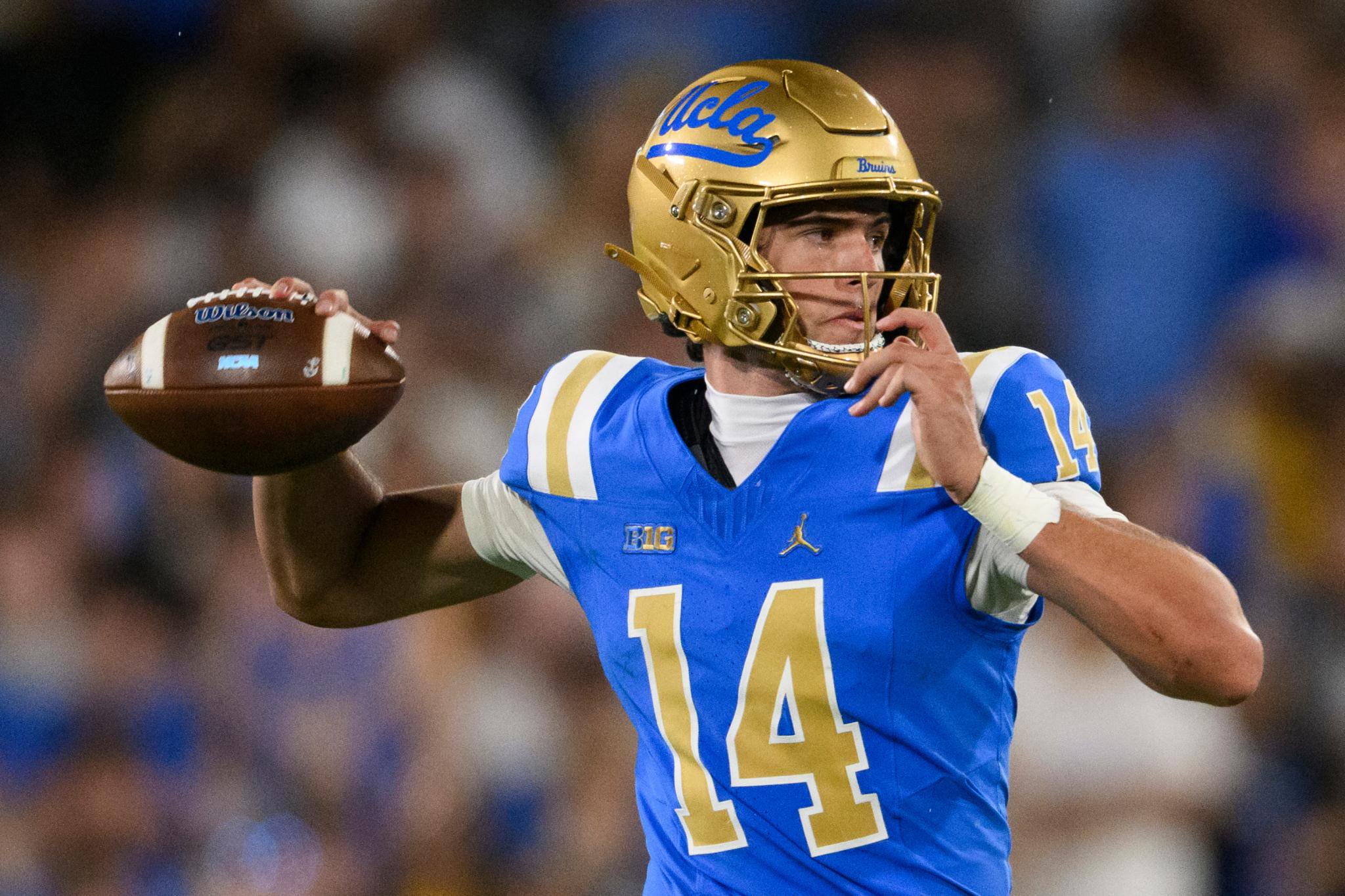 Ty Dieffenbach in a blue and gold UCLA football uniform, preparing to throw a football.