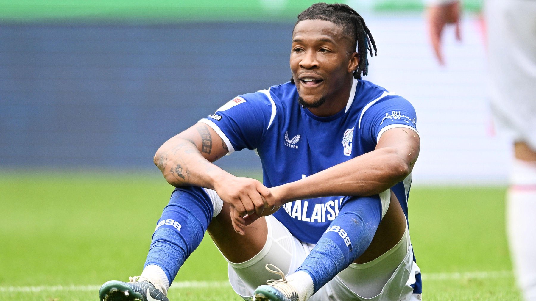 Gabriel Osho sat on the floor in blue and white Cardiff City kit