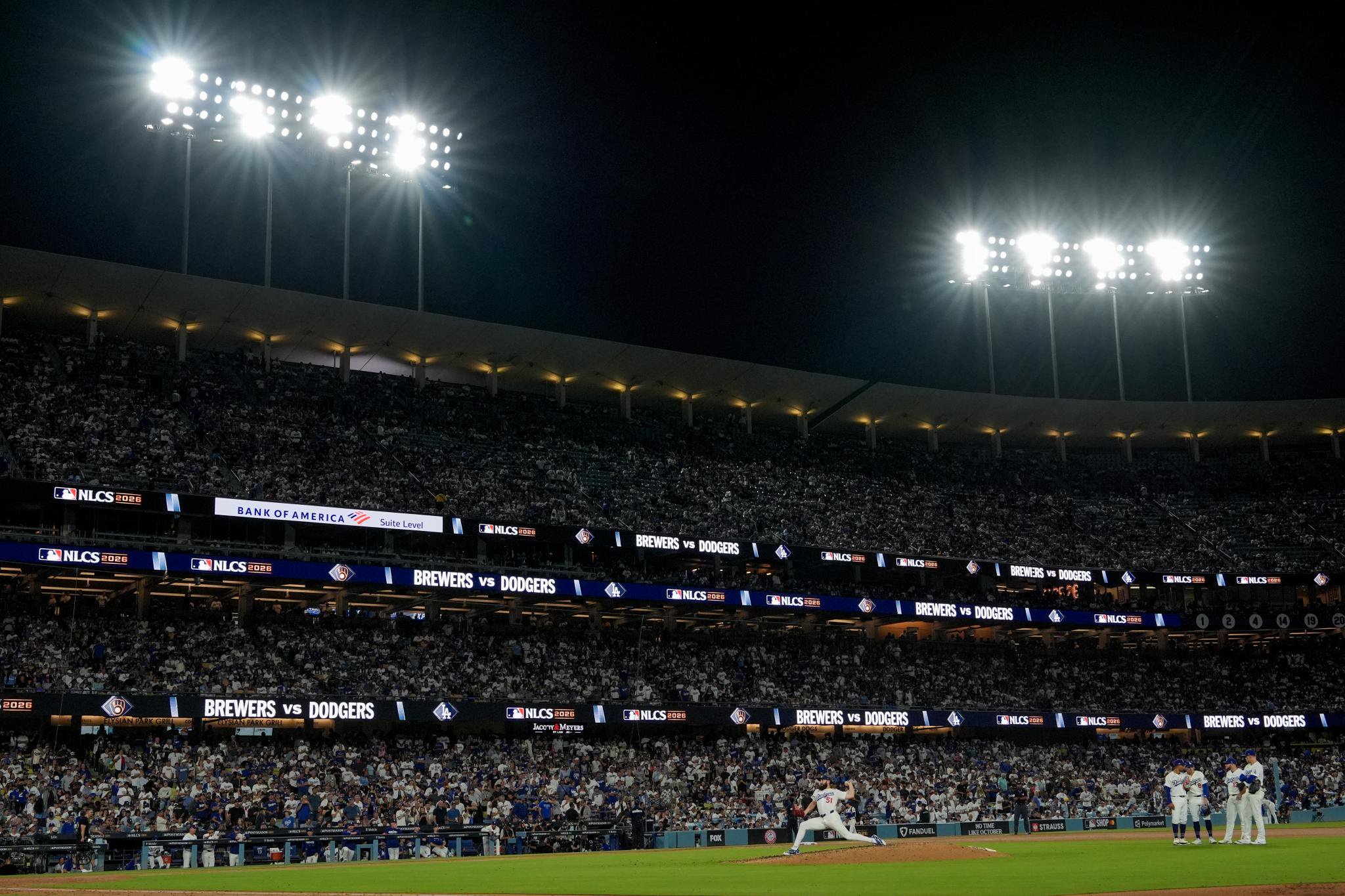 Los Angeles Dodgers pitcher Alex Vesia warms up during Game 4 of the National League Championship Series at a crowded stadium at night.
