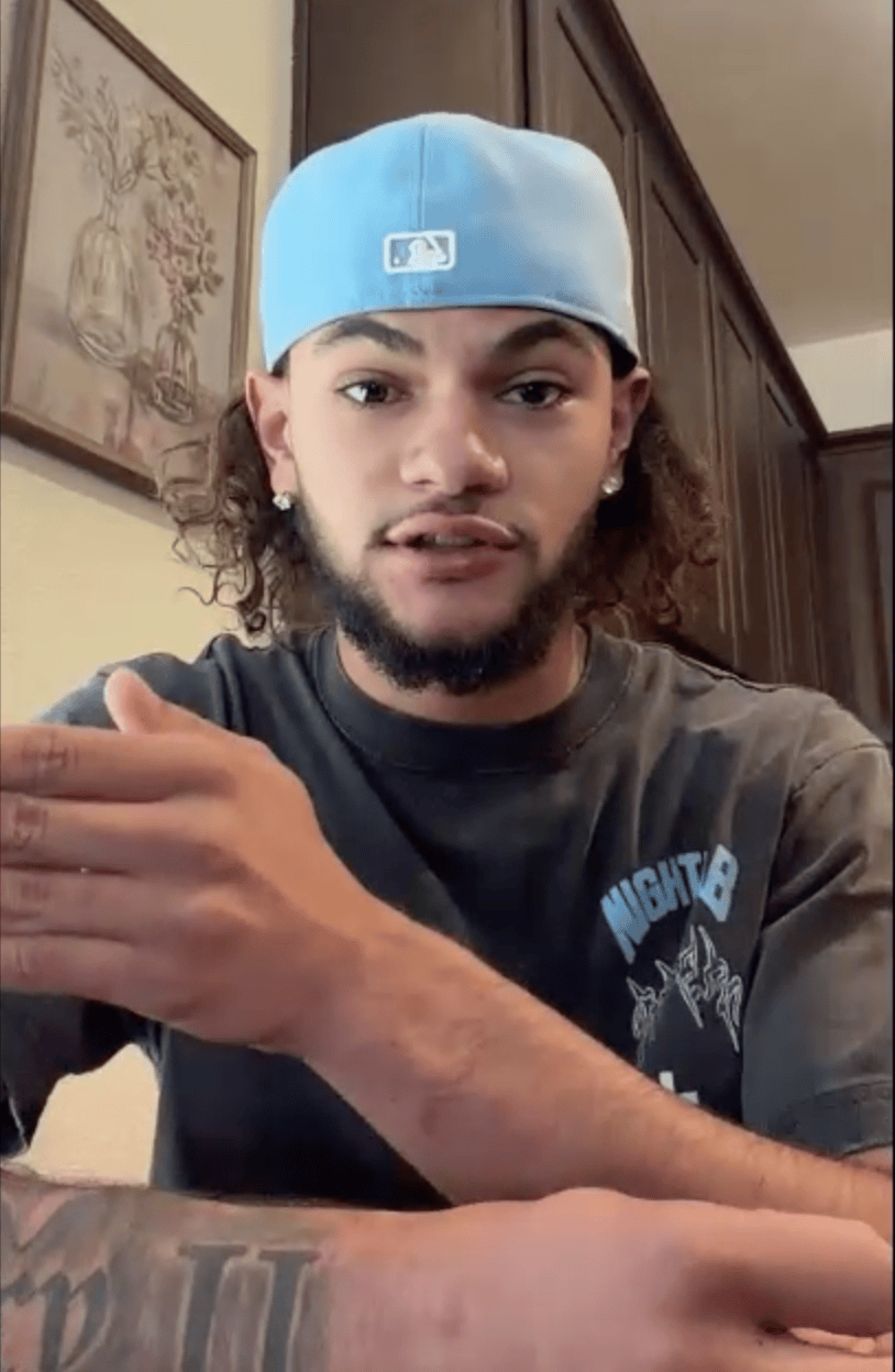 Terrance Avery speaks to the camera while wearing a light blue baseball cap and a dark t-shirt.