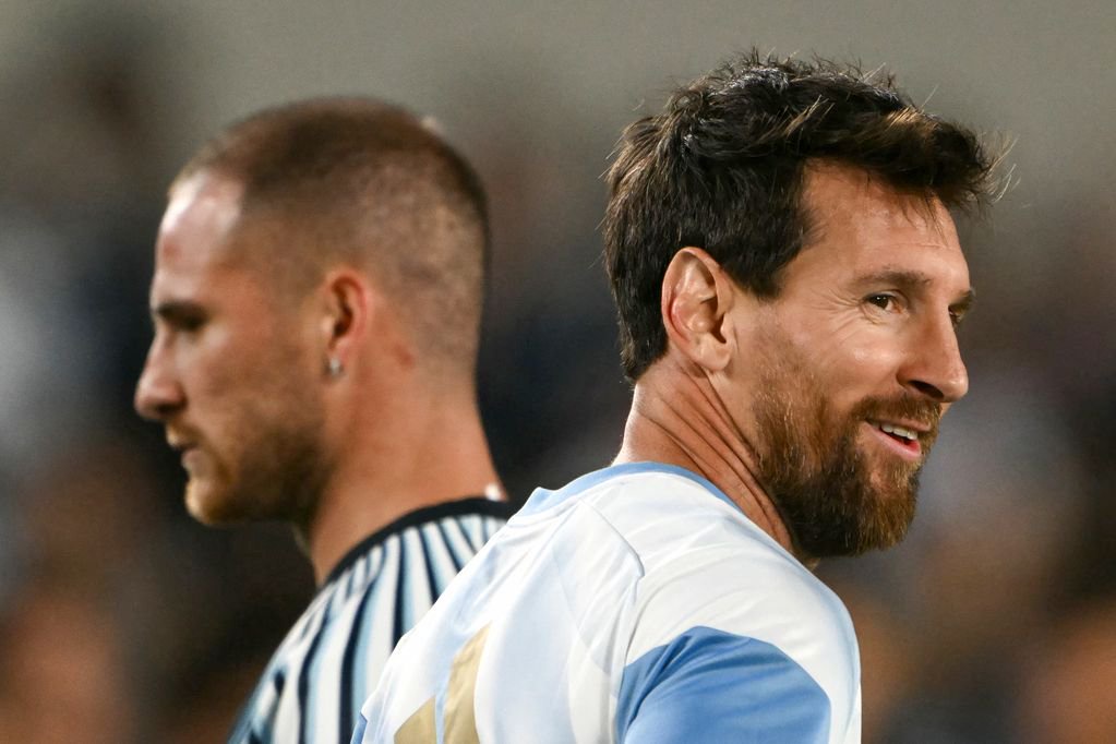 Argentina's forward #10 Lionel Messi (R) smiles next to his teammate midfielder #20 Alexis Mac Allister as they warm up ahead of the international friendly football match between Argentina and Benin