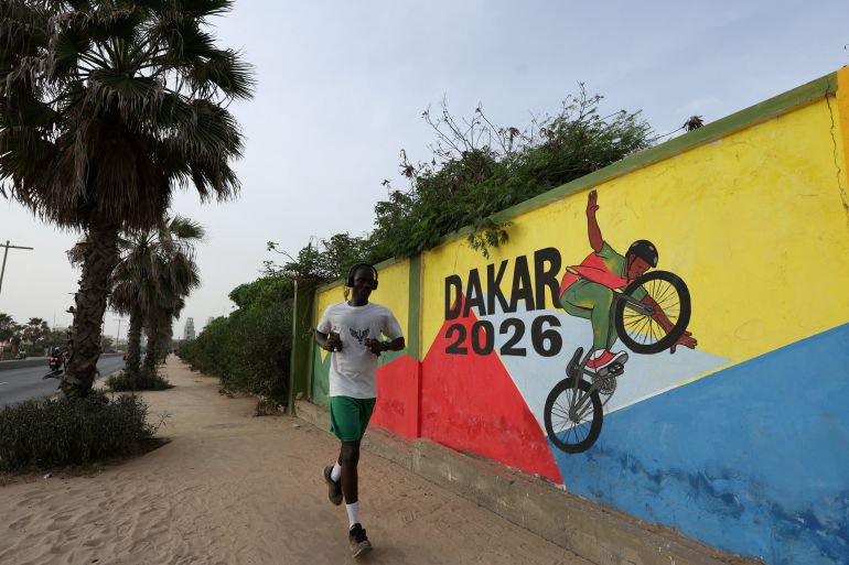 A man runs past a mural of Dakar 2026 as Senegal prepares to host the Youth Olympic Games, the first Olympic event to be held in Africa, in Dakar, Senegal, October 25, 2026. REUTERS/Misper Apawu
