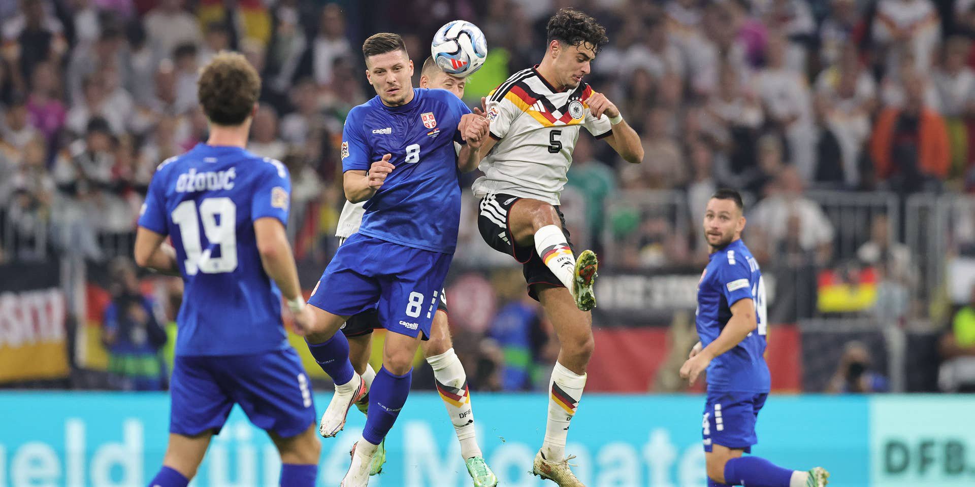 Luka Jović (l.) und Aleksandar Pavlović (r.) im Kopfballduell – beim Wiedersehen in der Nations League herrscht Geisterspiel-Atmosphäre.