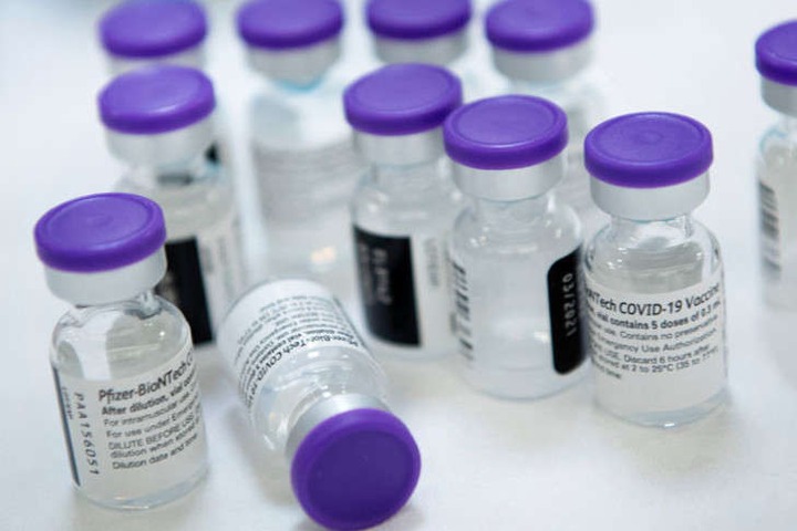 a plastic water bottle: In this file photo taken on 30 December 2020, vials of undiluted Pfizer COVID-19 vaccine are prepared to administer to staff and residents at the Goodwin House Bailey's Crossroads, a senior living community in Falls Church, Virginia.
