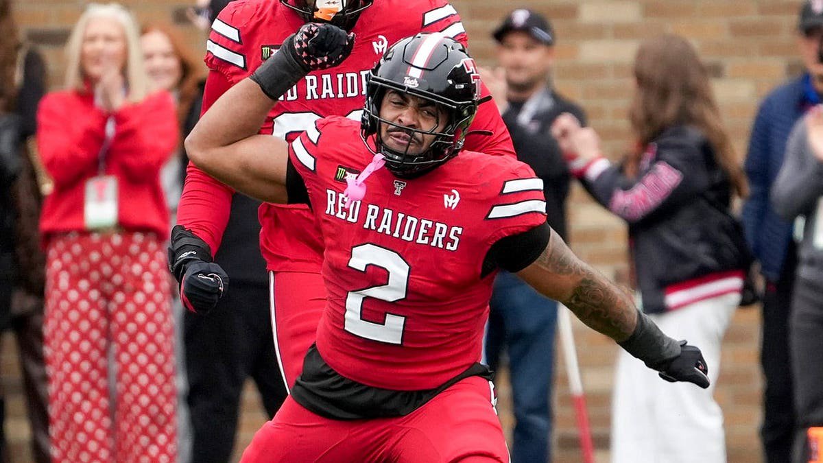 Trey White celebrates after recording a sack during a football game.