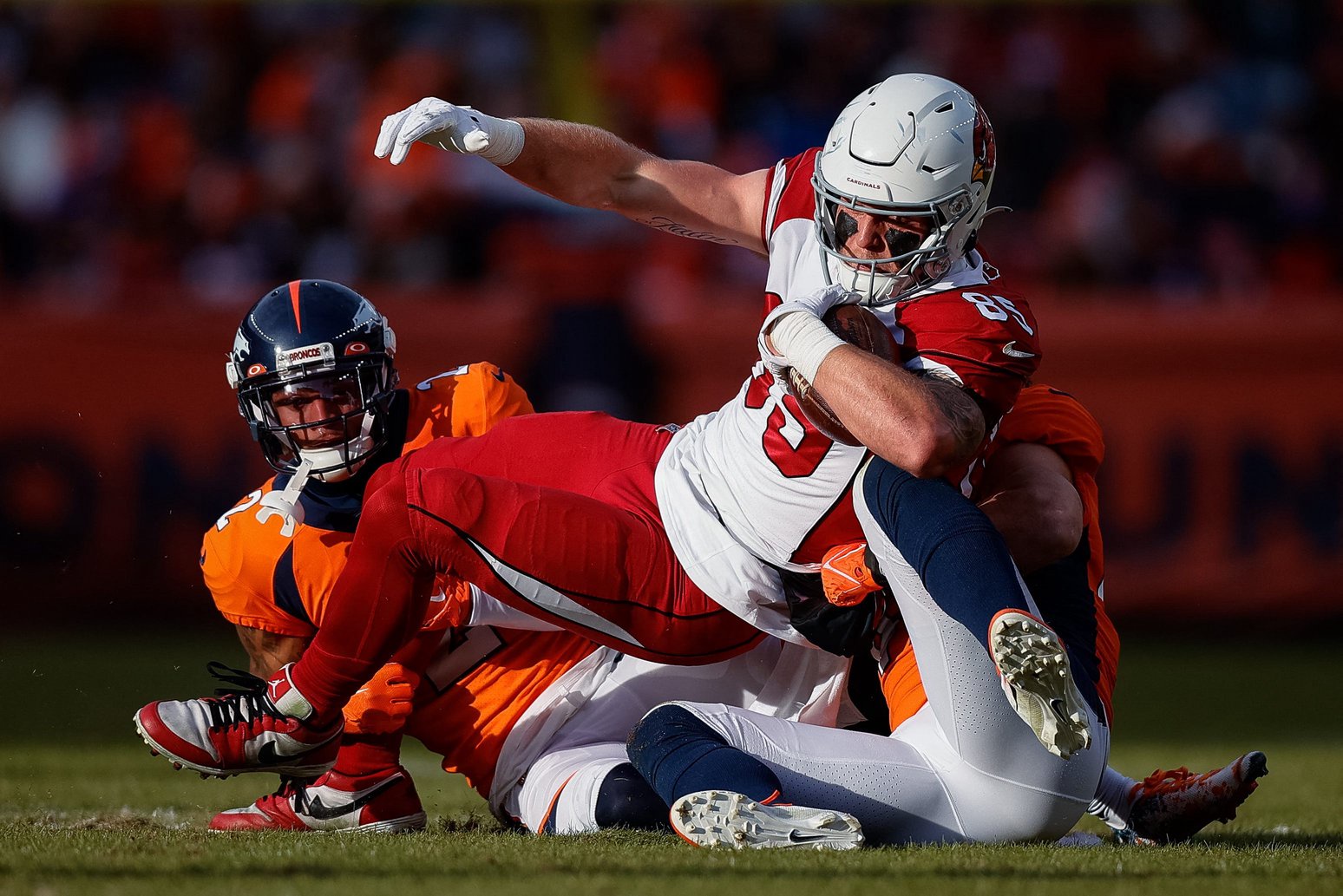 Dec 18, 2022; Denver, Colorado, USA; Arizona Cardinals tight end Trey McBride (85) is tackled by Denver Broncos linebacker Alex Singleton (49) and cornerback Pat Surtain II (2) in the second quarter at Empower Field at Mile High. (Isaiah J. Downing-USA TODAY Sports) 