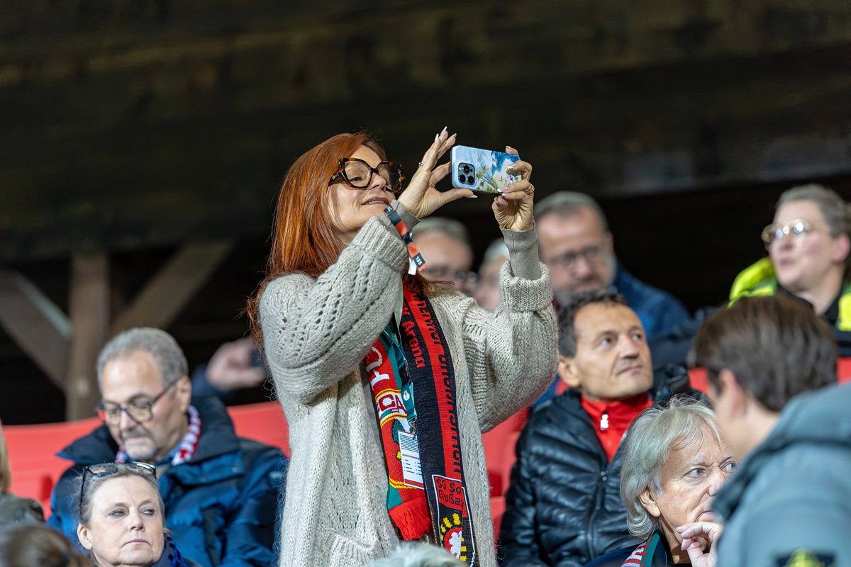 Schlagersängerin Andrea Berg fotografiert die Spieler beim Einlaufen von der Tribüne aus.